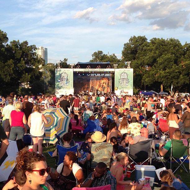 large crowd of people sitting and standing in lawn chairs