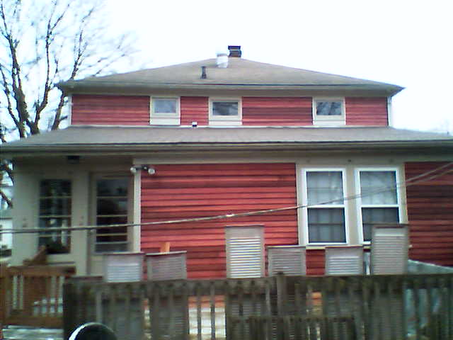 a two story red house with white trim