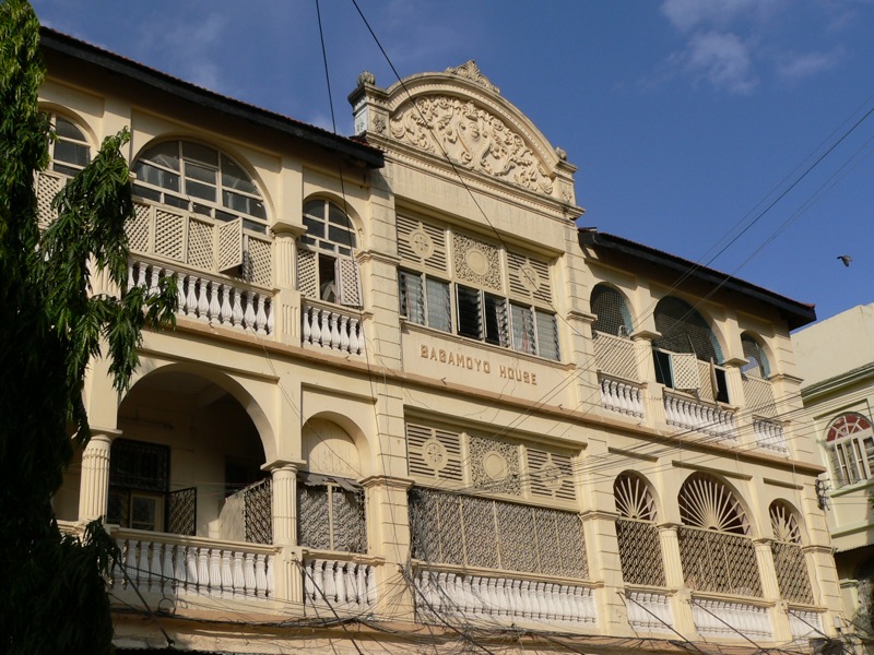 an old building with white balconies and wooden balconies