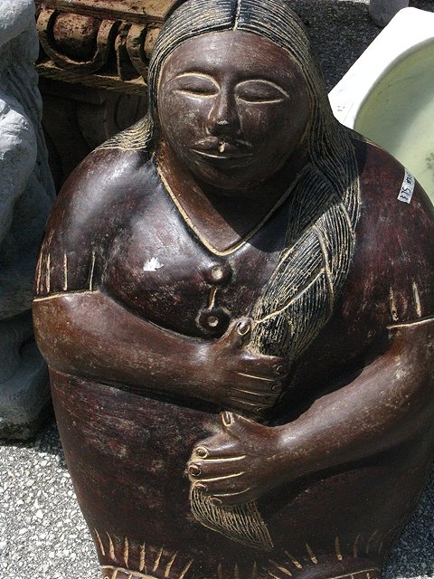 a ceramic statue in the shape of a woman holding a child