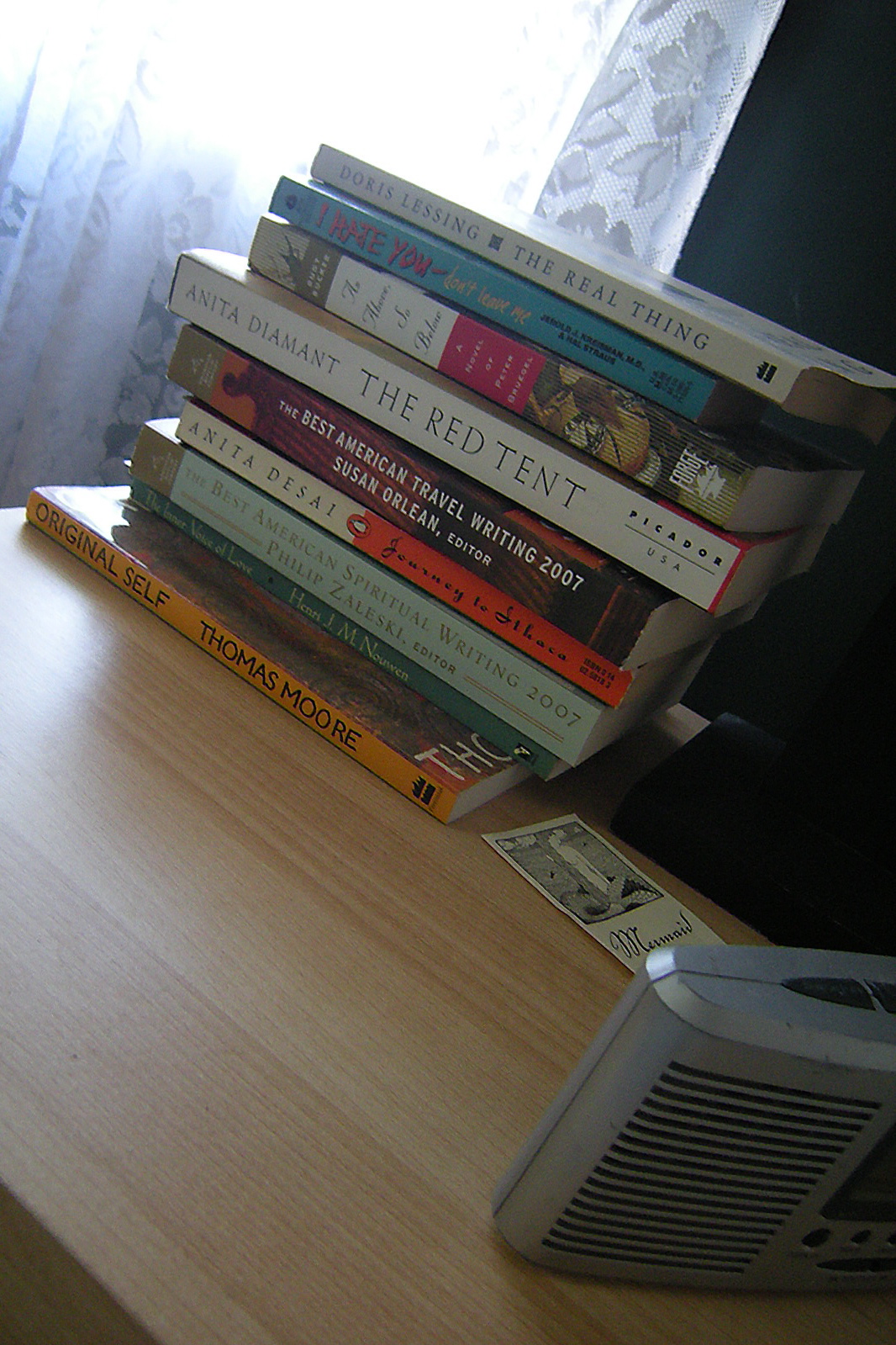 a stack of books on a table next to a small radio