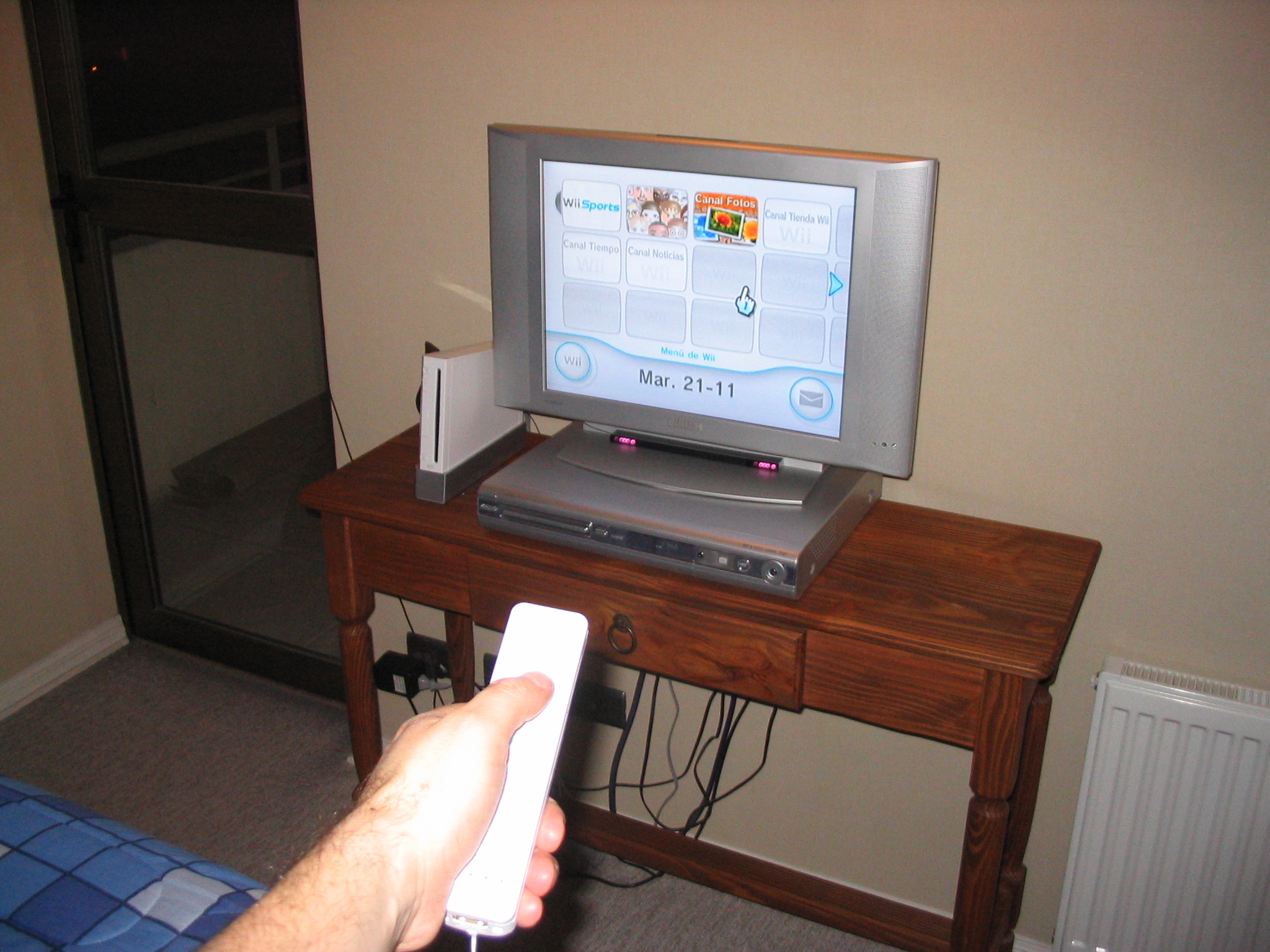 a person is holding a wii remote in front of a tv