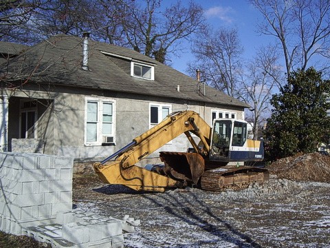 a excavator on a road in front of a house