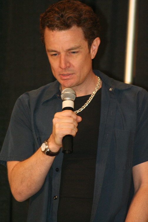 a man in black holding a microphone