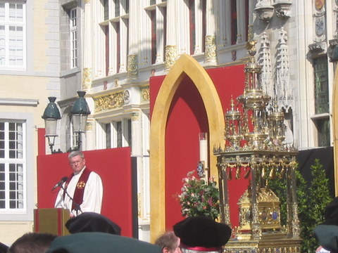 a man standing behind a podium with a cross