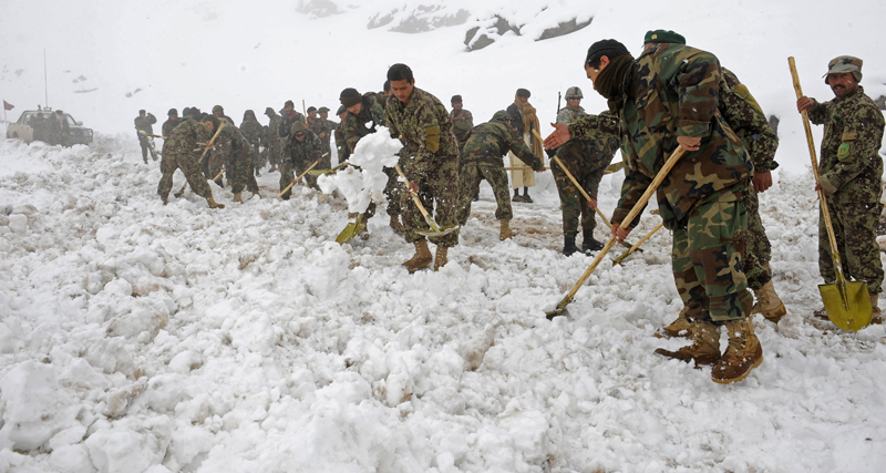 many men are shoveling and digging through some snow