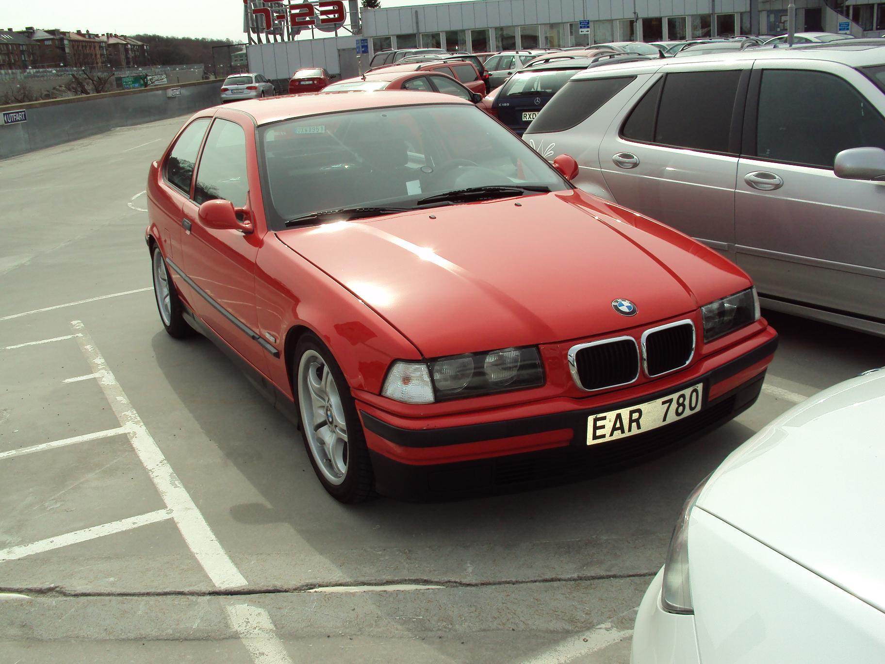 red bmw bmw car is sitting in a parking lot