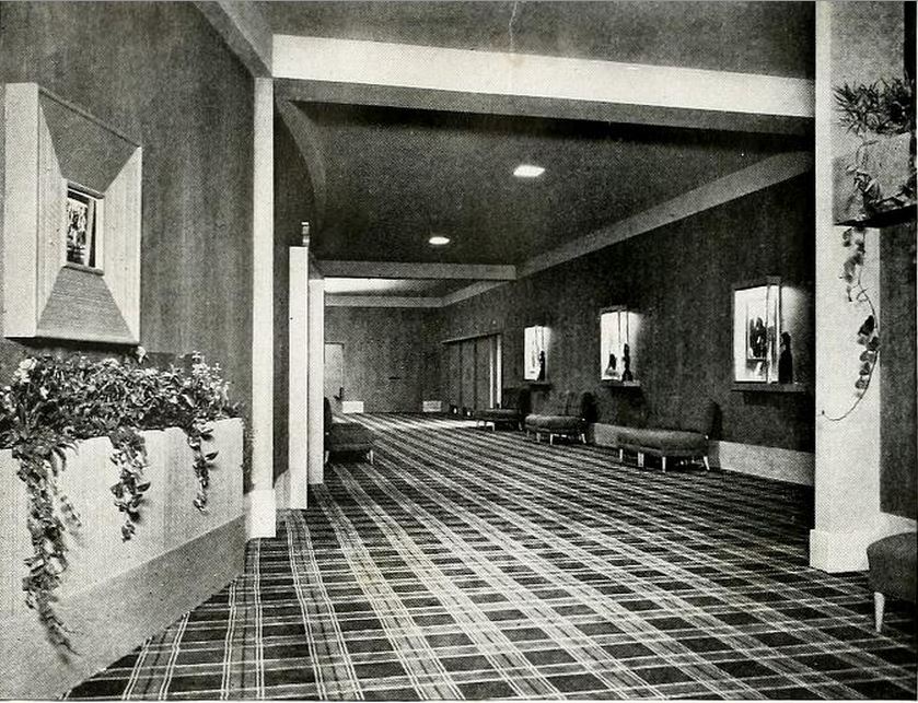 an open lobby and hallway with two chairs