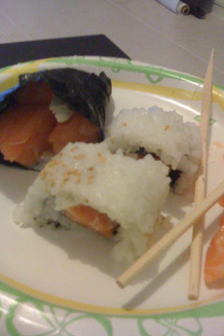 two sushi pieces are sitting on a plate with an orange slice