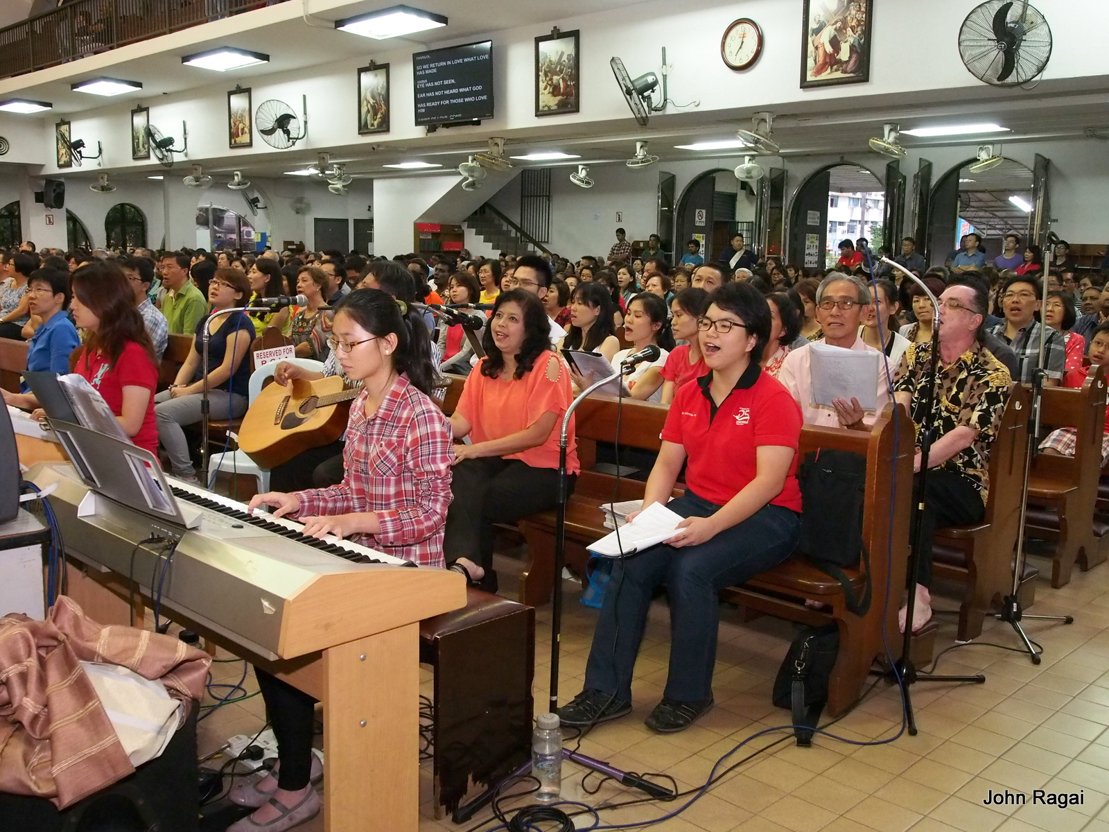 a large group of people sitting at long tables and using musical instruments