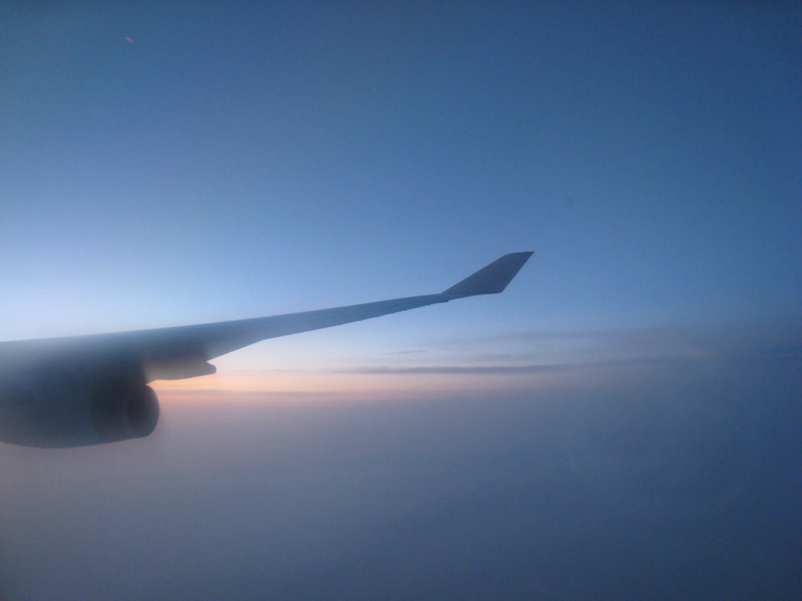 the wing of a plane flying over the ocean