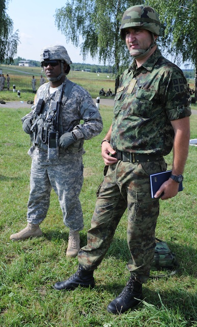 two military personnel, one in uniform and the other out