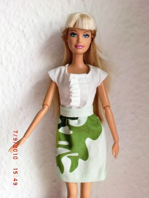 a barbie doll with white hair and a green dress