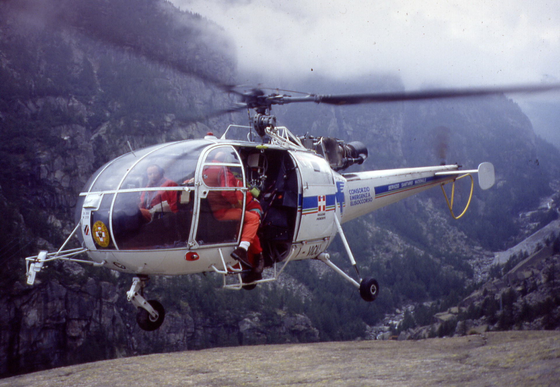 a helicopter with people inside flying over a mountain