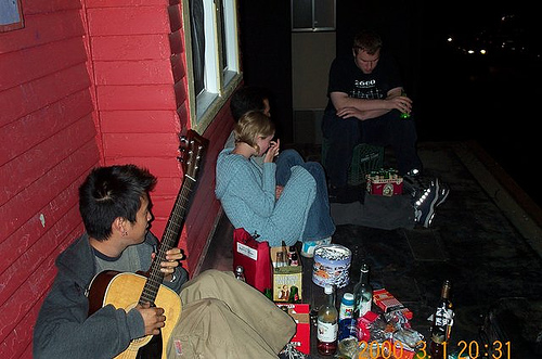 people are sitting outside by a red house