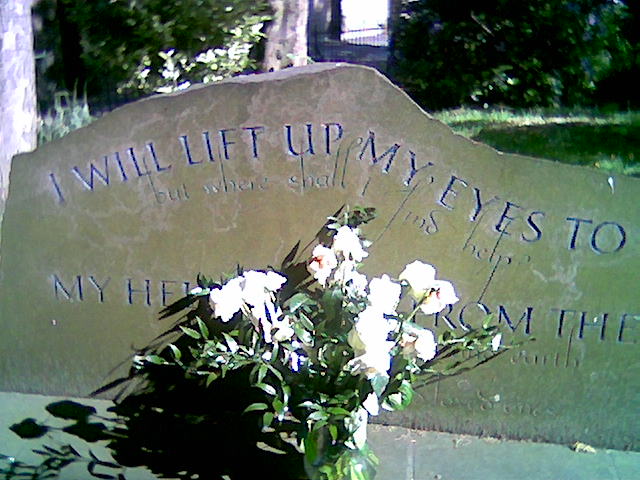 flowers are in the vase on the grave stone