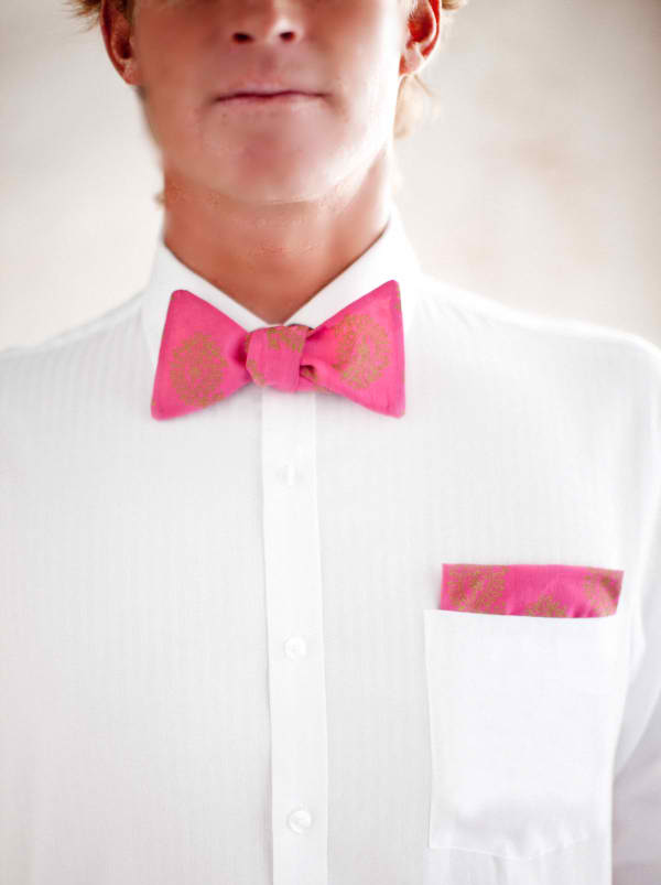 a man wearing a white shirt and pink bow tie