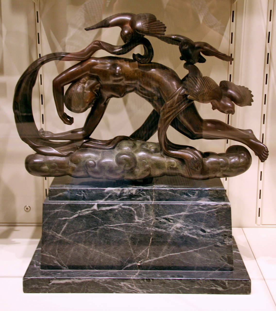 a bronze sculpture sitting on top of a marble pedestal