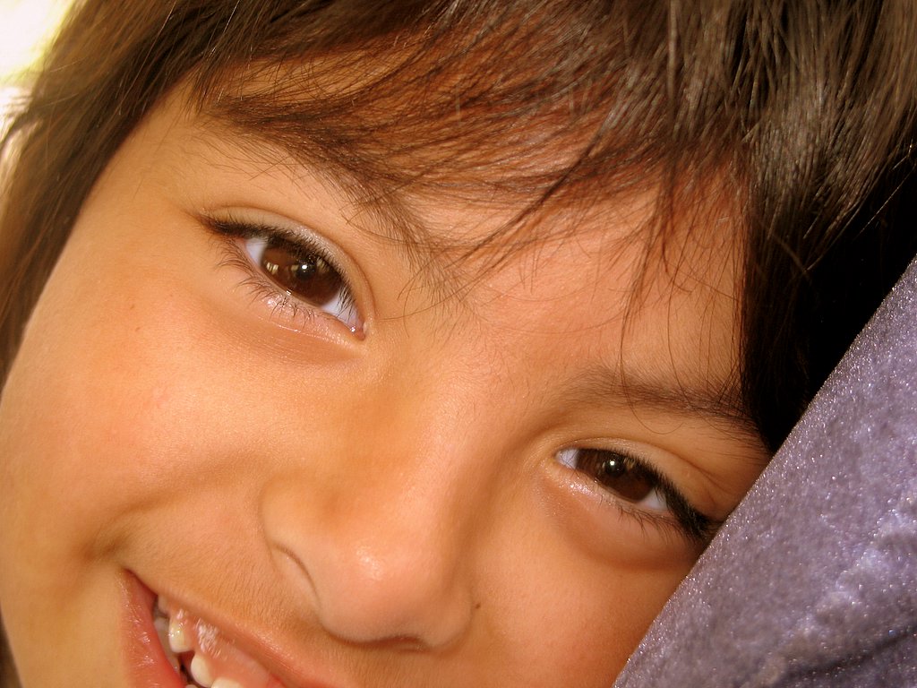 a child with a purple pillow smiling