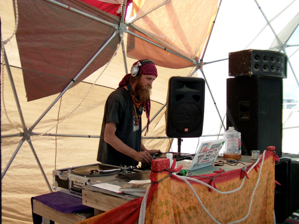 a man standing at a dj deck playing music