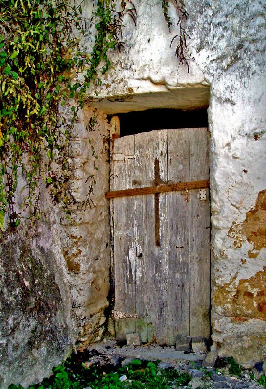 an old wooden door on an old stone wall