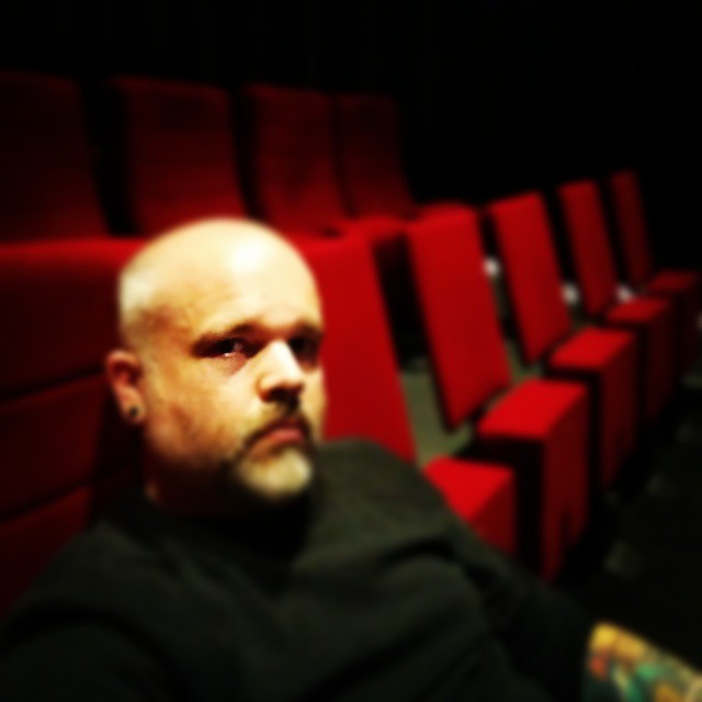 a man in the theater alone with red seats