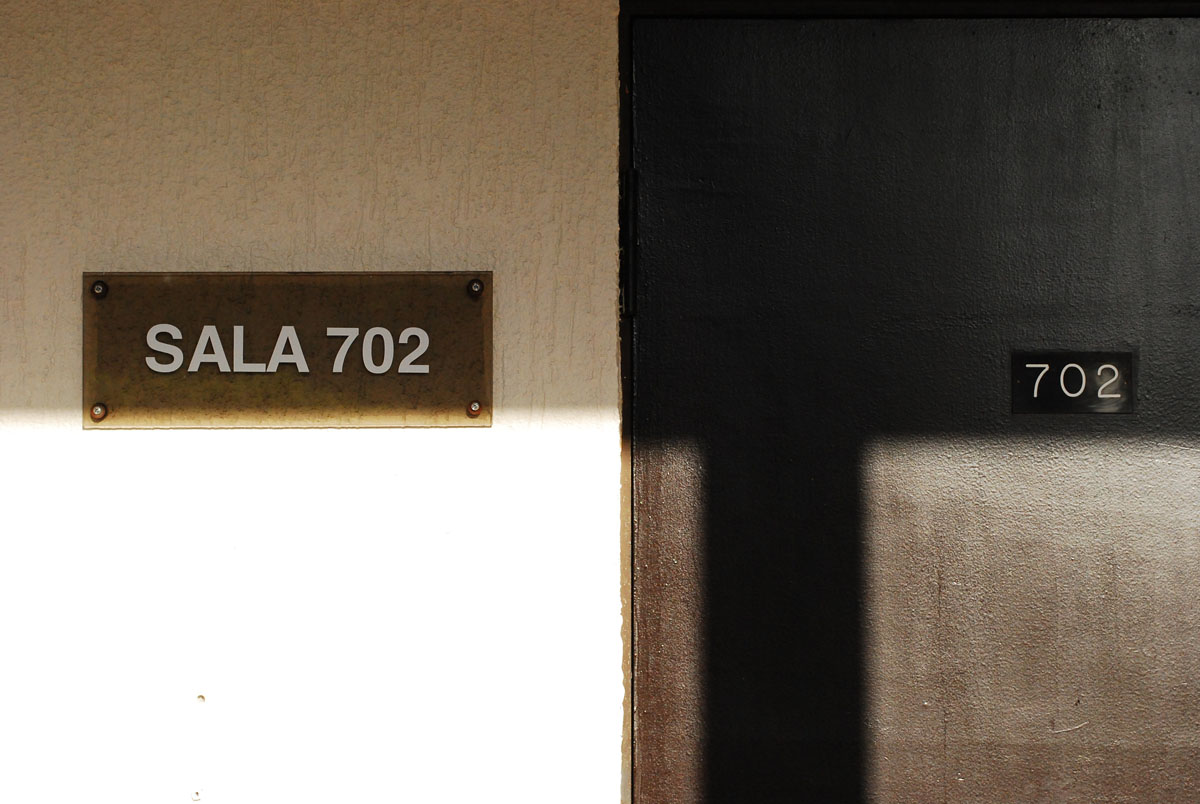 a brown metal sign next to a door