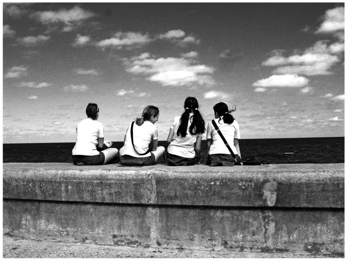 a group of people sitting next to each other at the beach