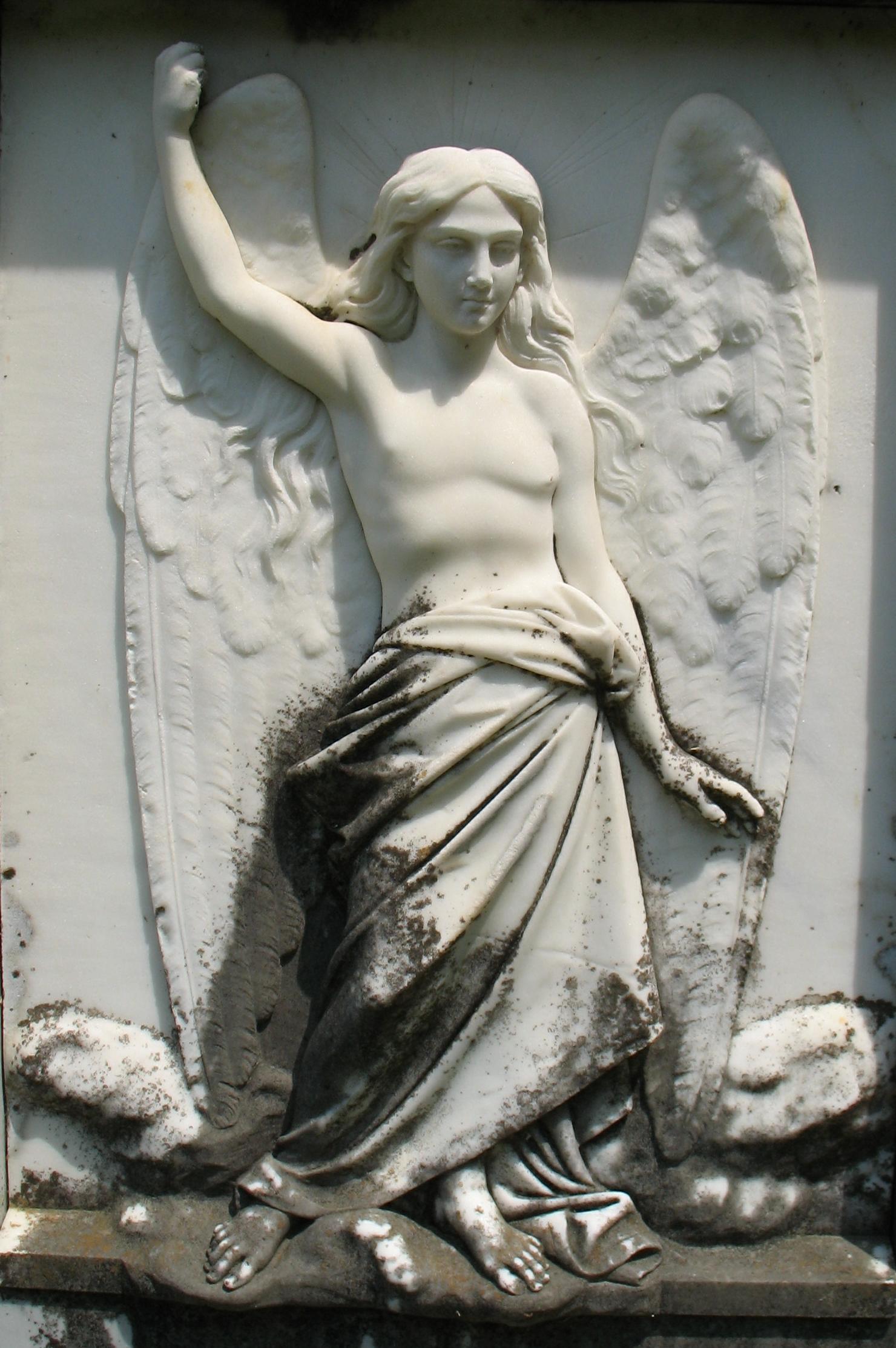 a statue of a woman laying down next to an angel