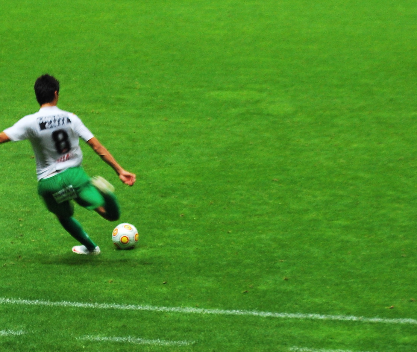 a soccer player is kicking a soccer ball on the field