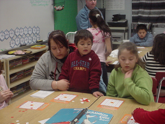 children sitting at the table in front of an adult looking