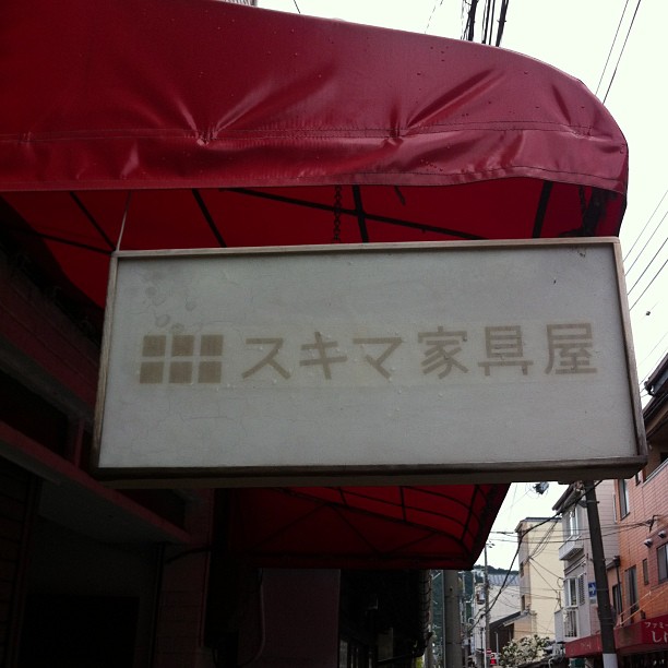 a sign attached to a red awning over the sidewalk