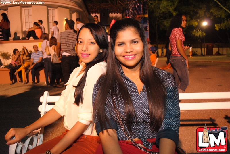 two young ladies sitting side by side in the evening