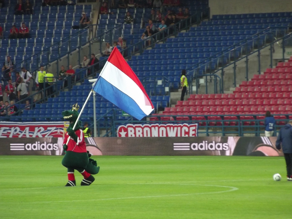 soccer players running across a field with a flag on one hand and a ball in the other