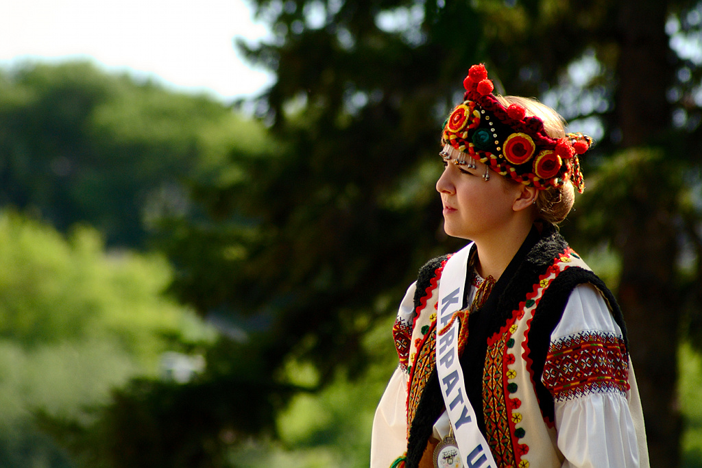 a woman in traditional dress is standing in the woods
