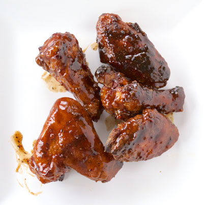 barbecued chicken wings with brown sauce on them