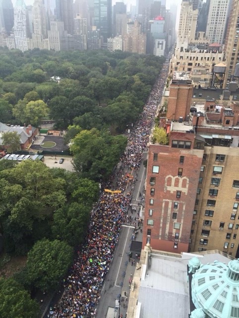 people are standing on the side of the street in front of buildings