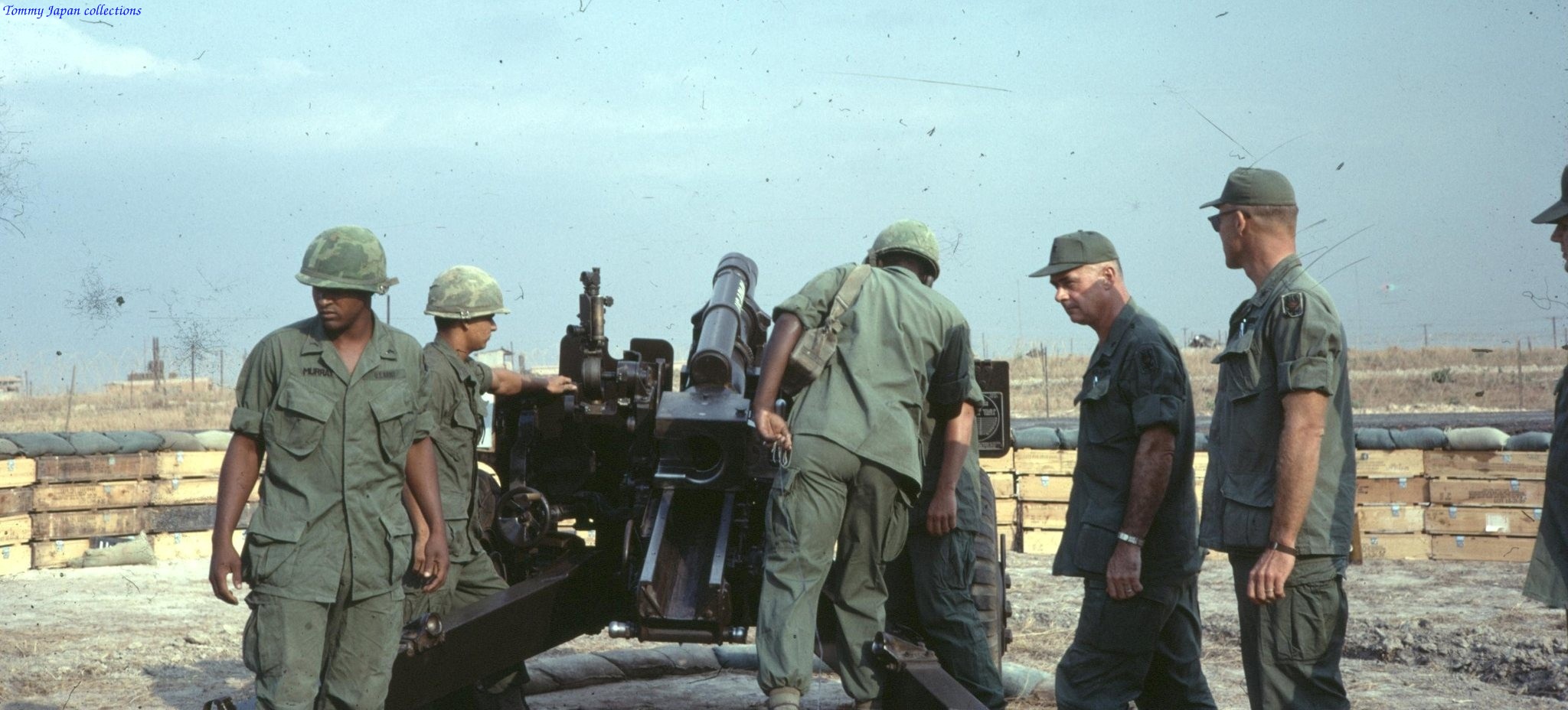 soldiers in fatigues standing next to an army vehicle