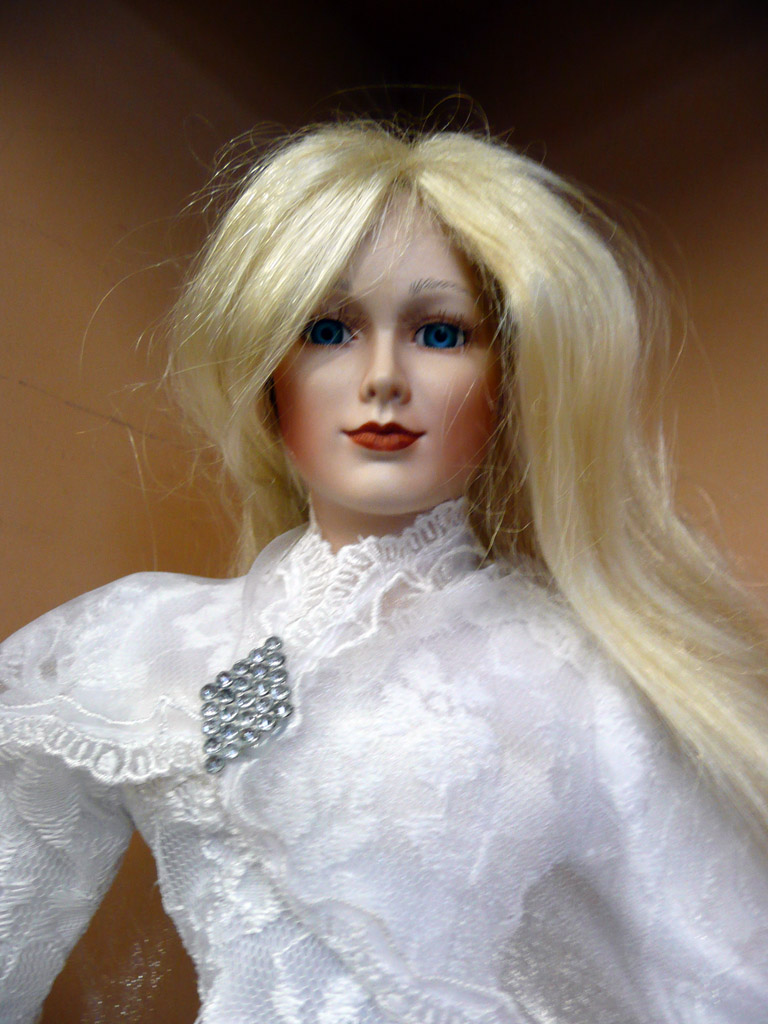 a doll with long blonde hair in white clothes