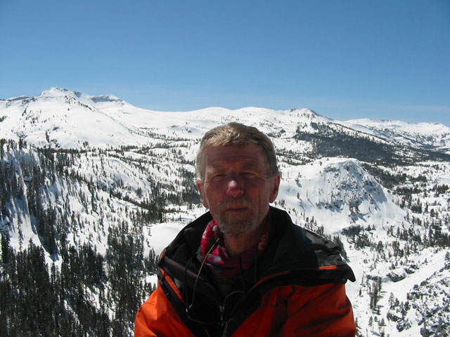 a man in a jacket is overlooking the snow covered mountains