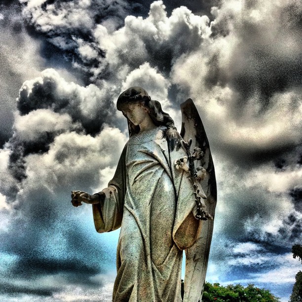 a statue of an angel holding an object in its hands