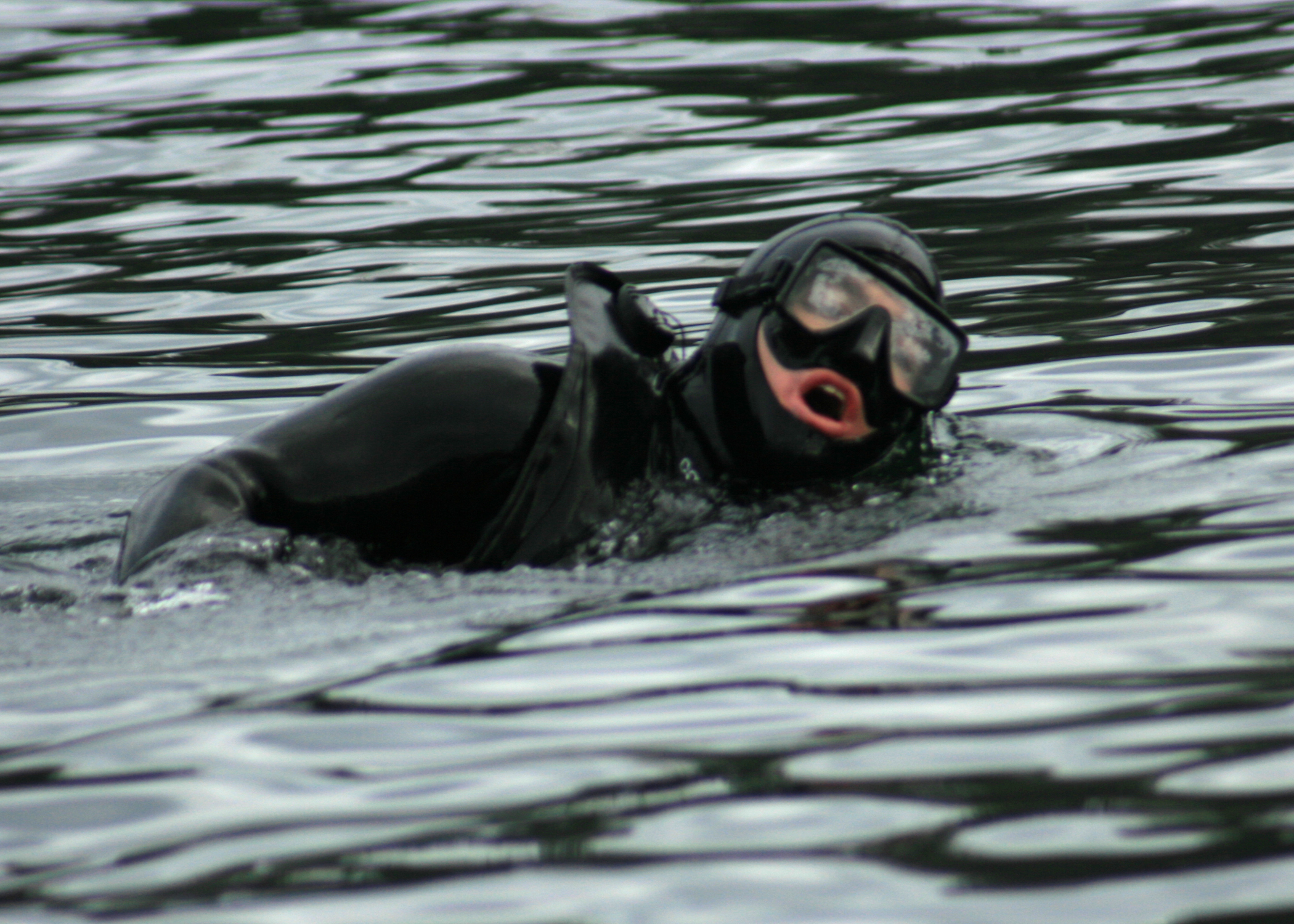 a man swimming in the water wearing a scuba suit