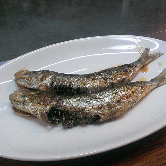two dried fish on a white plate