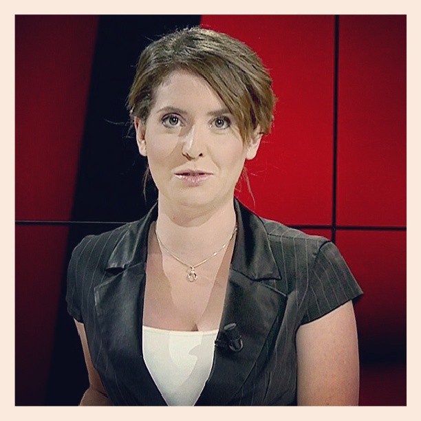 woman looking forward while talking to news set