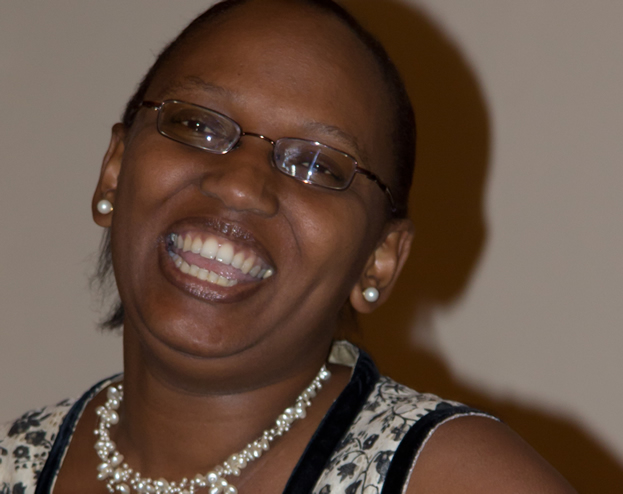 a woman wearing glasses smiles and smiles for the camera