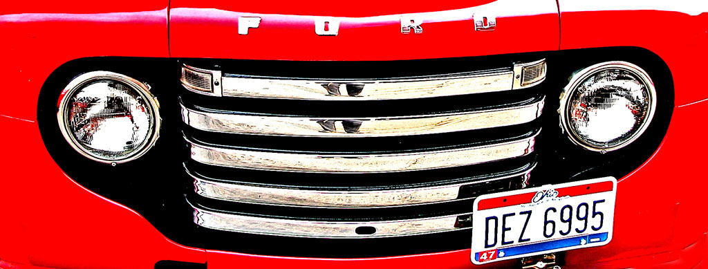 close up pograph of the grill and headlights of an antique truck