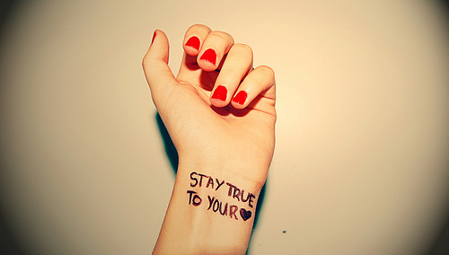 a woman's hand with a tattoo that says stay true to your