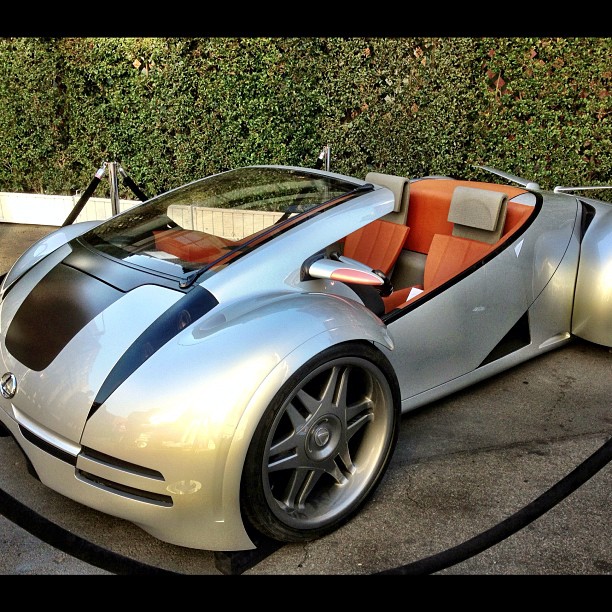 a silver bugatti with an orange seat sits on the ground