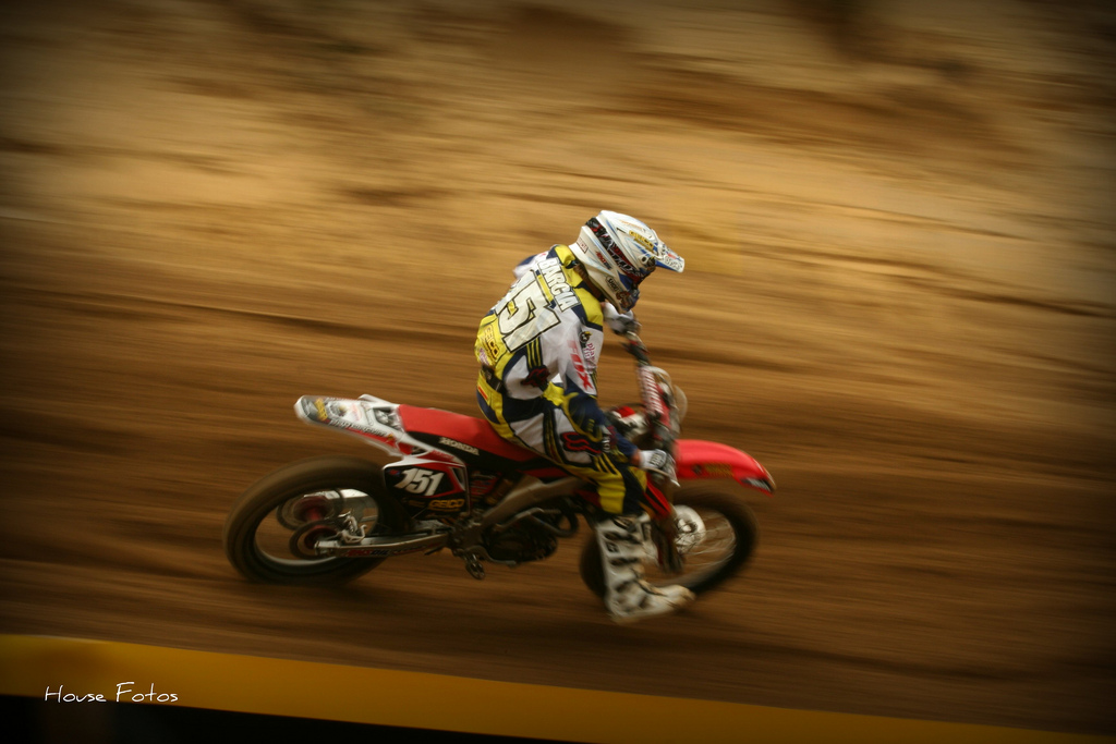 a person wearing a helmet and riding a red dirt bike