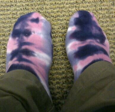 the bottom view of someone's feet, wearing slippers that tie dye
